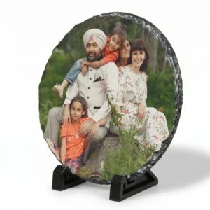 A side angle perspective view of a round shape personalized rock stone frame by upahar18 on a white background. The front features a custom photo printed of a family, while the angled view highlights the rustic side thickness of the natural rock slate and its stable black base stands.