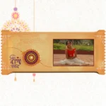 Horizontal custom Nestlé KitKat by upahar18 with a golden customize design wrapper showing a large rakhi emblem, Bengali typography, and a photo chocolate print of a smiling young girl in traditional attire.