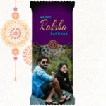 Custom printed Nestlé KitKat bar by upahar18 with a purple customize design wrapper showing an English Rakhi greeting, a traditional rakhi thread illustration, and a real photo chocolate print of a smiling brother and sister sitting outdoors.