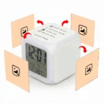 A graphic illustration detailing the customization options of the white Upahar18 personalized photo printed led alarm clock. The cube clock sits at an angle showing its digital screen and a top panel printed with the text '4 HD Photos, LED Color Display, Perfect Gift, Memory Clock, Custom Made'. Four square light-orange placeholder panels, each showing a black mountain-and-plus image icon, hover around the sides with curved red arrows pointing toward the clock faces, illustrating that up to four custom photos can be printed on its different sides.